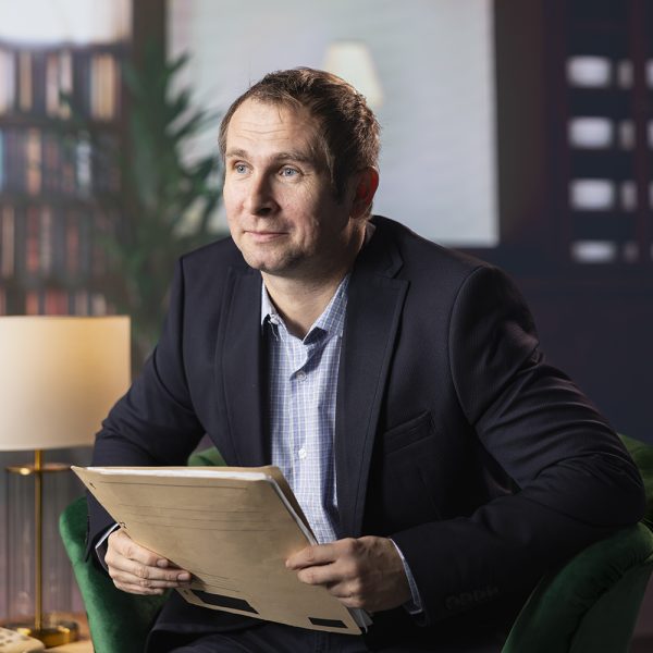 Diverse CIA secret agents review mission documents and evidence gathered in a classy library at the government headquarters. Confidential discussion between undercover informers.